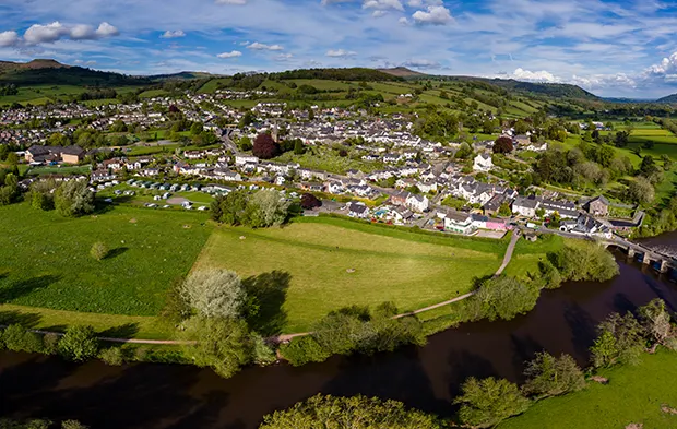 Aerial view of a Welsh town and green fields on a sunny day