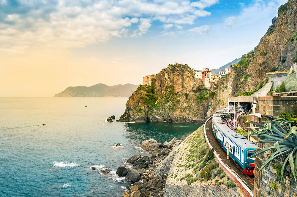 An Italian train goes along the tracks next to the sea in Liguria, on the coast of north western Italy.